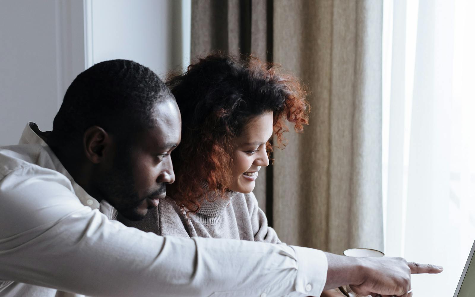 Couple échangeant sur une stratégie financière devant un ordinateur
